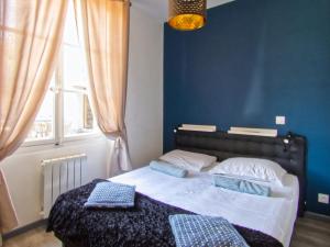 Un dormitorio con una cama con paredes azules y una ventana en La petite Maison, en Grenoble