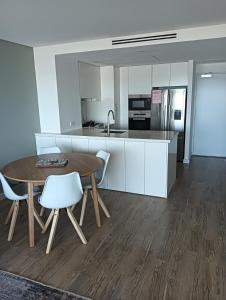 eine Küche mit einem Holztisch und weißen Schränken in der Unterkunft Kirra Surf Apartments in Gold Coast