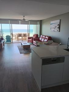 ein Wohnzimmer mit einem Sofa und einem Tisch in der Unterkunft Kirra Surf Apartments in Gold Coast