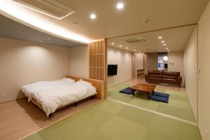 a bedroom with a bed and a living room at UTAKATA HOTEL HIMEJI in Himeji