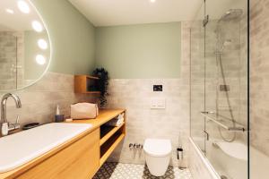 a bathroom with a tub and a toilet and a sink at harry's home Graz-Smart City hotel & apartments in Graz