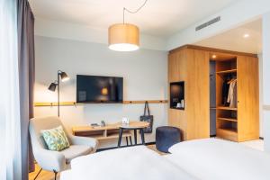 a hotel room with a bed and a desk and chair at harry's home Graz-Smart City hotel & apartments in Graz