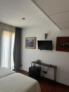 a hotel room with two beds and a flat screen tv at Hotel Plaza Inn in Figueres