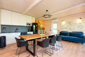 a kitchen with a dining table and a blue couch at Namelis ant ežero kranto "Giliaus Elingas" in Tytuvėnai