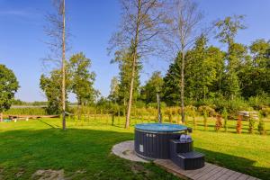 a hot tub in the middle of a park at Namelis ant ežero kranto "Giliaus Elingas" in Tytuvėnai