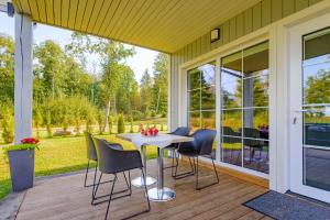 a screened porch with a table and chairs on it at Namelis ant ežero kranto "Giliaus Elingas" in Tytuvėnai