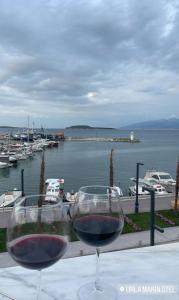 twee glazen wijn zittend op een tafel met een haven bij Urla Marin otel in Izmir