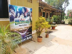 a sign on the side of a building with plants at Colva beach Xaviers Guest House in Colva