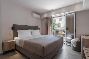 um quarto com uma cama grande e uma varanda em Piraeus City Hotel em Pireu