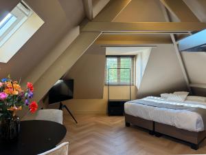 - une chambre mansardée avec un lit et une table dans l'établissement Breda City Apartments, à Breda