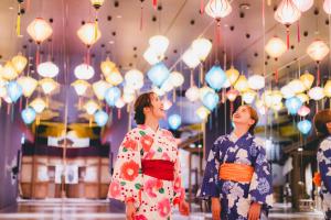 Un groupe de personnes en kimonos qui regardent les lumières. dans l'établissement Art Hotel Osaka Bay Tower, à Osaka