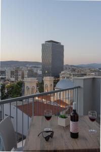 uma mesa com dois copos de vinho numa varanda em Piraeus City Hotel em Pireu