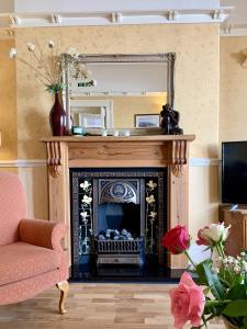 a living room with a fireplace and a mirror at Seaclyffe Hotel Ltd in Llandudno