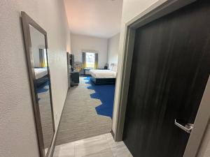 a room with a hallway with two beds and a door at Microtel Inn & Suites by Wyndham Amarillo West in Amarillo