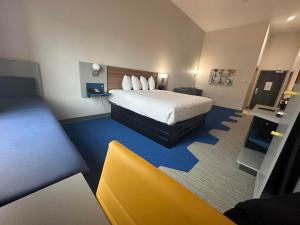 a hotel room with a bed and a yellow chair at Microtel Inn & Suites by Wyndham Amarillo West in Amarillo