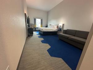 a hotel room with a bed and a couch at Microtel Inn & Suites by Wyndham Amarillo West in Amarillo