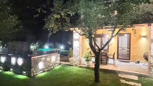 un patio trasero por la noche con un árbol y luces en Natura Bungalows, en Limenas