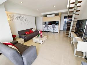 a large living room with a couch and a staircase at Penthouse Espectacular Vista Cd A.C. WiFi 300mbps in Guadalajara