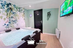 Cette chambre dispose d'un bain à remous et d'une télévision. dans l'établissement LA FEUILLERAIE N2-Standingappart-Wifi-Proche ville, à Fontenay-le-Comte