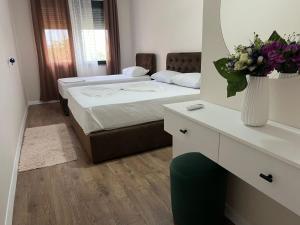 - une chambre avec 2 lits et un vase de fleurs dans l'établissement SARVI Apartments, à Durrës