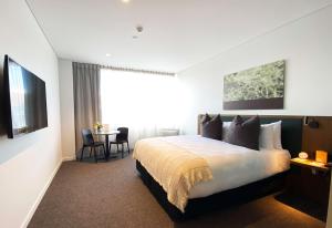 a hotel room with a bed and a table at Sudima Queenstown Five Mile in Queenstown