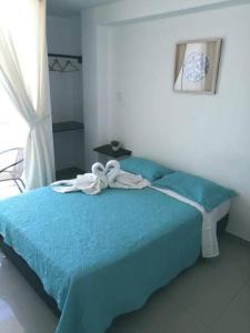 Un dormitorio con una cama azul y una ventana en Hotel Guest House Inkayacu-Paracas, en Paracas