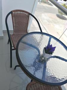 una mesa de cristal con un ramo de flores púrpuras. en Hotel Guest House Inkayacu-Paracas, en Paracas