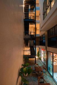 an apartment building with tables and chairs in a courtyard at HẢI AN HOTEL in Bao Loc