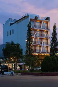 a large building with a sign in front of it at HẢI AN HOTEL in Bao Loc