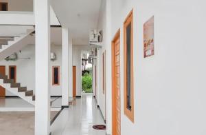 einen Flur eines Hauses mit weißen Wänden und Treppen in der Unterkunft OYO 93306 Homestay Permana Supadio Airport in Pontianak