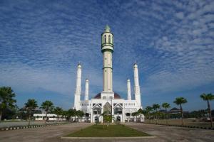 ein großes weißes Gebäude mit einem Uhrturm darauf in der Unterkunft OYO 93306 Homestay Permana Supadio Airport in Pontianak