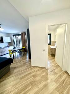 a living room with wooden floors and a dining room at Suites Dreams Fiumicino River in Fiumicino