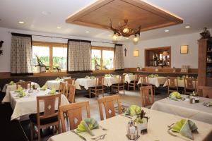 une salle à manger avec des tables et des chaises blanches dans l'établissement Appart-Hotel Wildererstuben, à Bodenmais