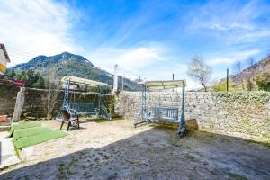 2 literas en un patio junto a una pared de piedra en The Kanchanikoot - Luxury Comfort ! Travellers Delight ! Budget Friendly ! Prime Location ! Guest Favourite, en Manali