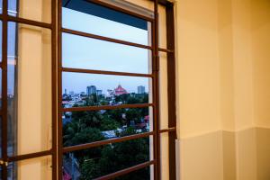 ein offenes Fenster mit Stadtblick in der Unterkunft Manhas Olympus in Ernakulam