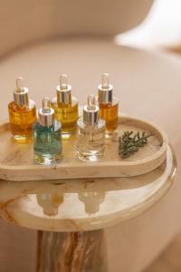 a shelf with four bottles of essential oils on it at Hôtel Singulier Bordeaux - Boutique Hôtel & Spa Anne Semonin in Bordeaux