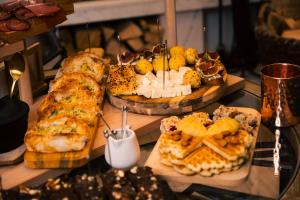 una mesa cubierta con diferentes tipos de pan y repostería en Casa di Pino Eco Lodge, en Žabljak