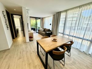 une salle à manger avec une table et un salon dans l'établissement Departamento Premium con Piscina y Cochera, à Pinamar