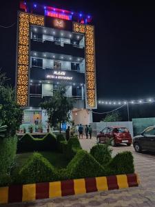 a building with people walking in front of it at night at MAAN Hotel in Alwar