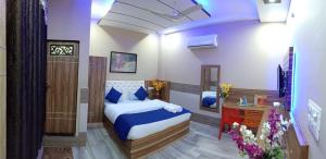 a bedroom with a bed and a table in a room at MAAN Hotel in Alwar