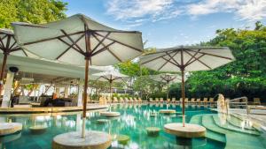 een zwembad met parasols in een resort bij Bali Garden Beach Resort in Kuta