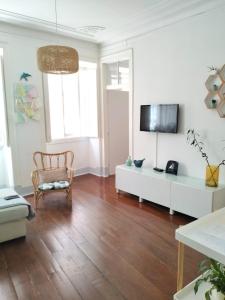 een woonkamer met een tv aan een witte muur bij Bird's Nest Lisbon Apartment in Lissabon