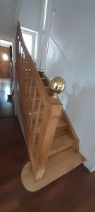 eine Holztreppe mit einem goldenen Ball auf der Seite in der Unterkunft Kooglof Maison in Ostwald