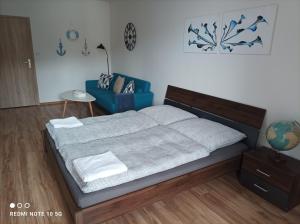 a bedroom with a bed and a blue chair at Krásny apartmán v centre Rožňavy in Rožňava