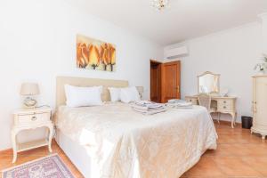 a white bedroom with a bed and two tables at Tavira Casa Jenny in Tavira