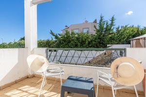 a balcony with two chairs and two hats on it at Tavira Casa Jenny in Tavira