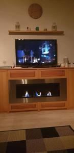 a living room with a tv and a fire place at Апартамент Four Seasons in Bansko