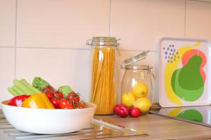 - un comptoir de cuisine avec un bol de légumes et une planche à découper dans l'établissement Ferienwohnung Helgoland, à Dorum Neufeld