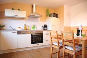 une cuisine avec une table en bois et une salle à manger dans l'établissement Ferienwohnung Helgoland, à Dorum Neufeld