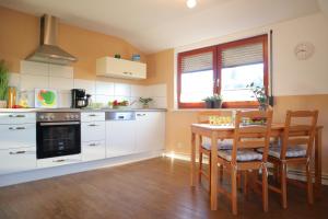 - une cuisine avec une table, une table et des chaises dans l'établissement Ferienwohnung Neuwerk, à Dorum Neufeld